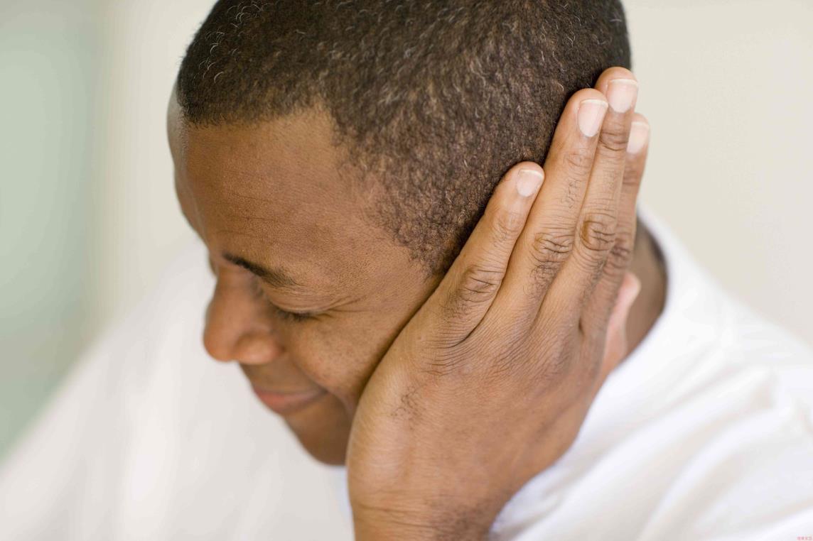 A man covering his aching ear
