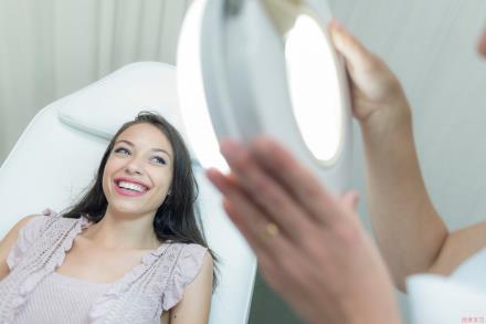 A woman smiling at the dermatologist's office