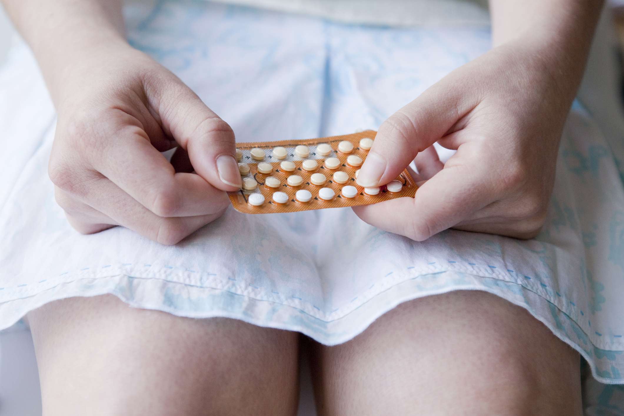 Woman holding pack of birth co<em></em>ntrol pills