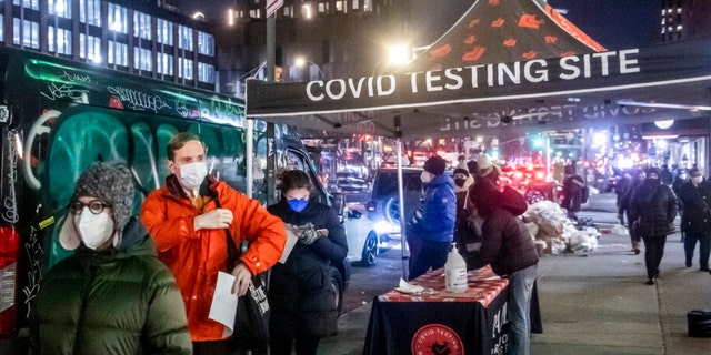 People wait on line to get tested for COVID in the Lower East Side on Tuesday, Dec. 21, 2021, in New York. (AP Photo/Brittainy Newman)
