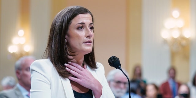 Cassidy Hutchinson, a top aide to Mark Meadows when he was White House chief of staff in the Trump administration, gestures toward her neck as she retells a story involving President Trump as the House Jan. 6 select committee holds a public hearing on Capitol Hill on Tuesday, June 28, 2022. 