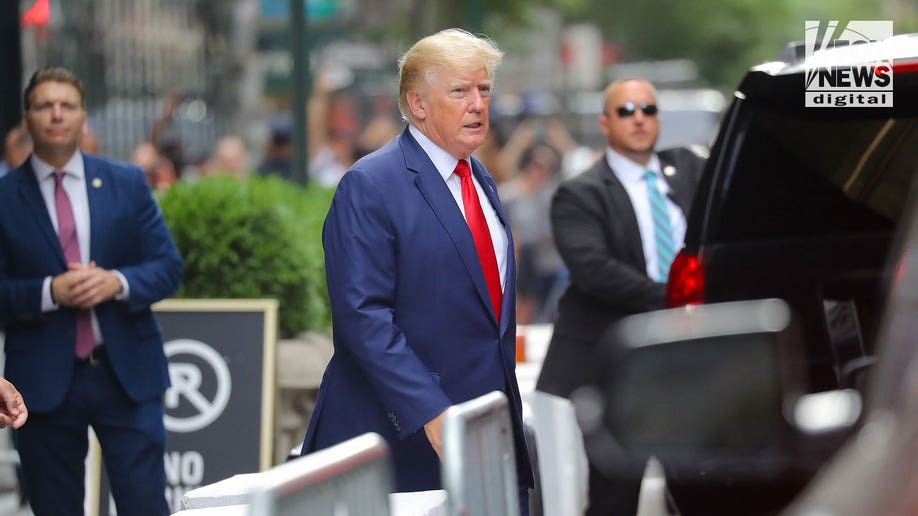 Do<em></em>nald Trump wearing a red tie and blue suit walking on the streets of New York City