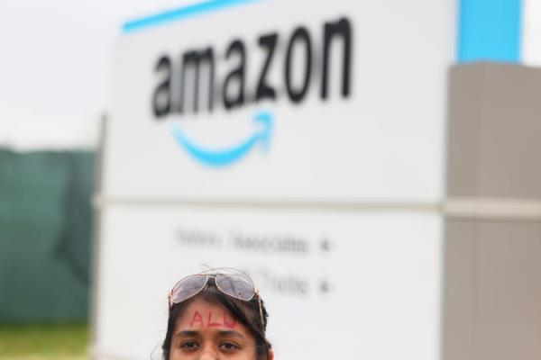 NEW YORK, NEW YORK - APRIL 25: Pranama Wagollawatte speaks to members of the media as she wears the letters "ALU" on her forehead at the entrance of the LDJ5 Amazon Sort Center on April 25, 2022 in New York City. The LDJ5 Amazon Sort Center is holding a vote to unio<em></em>nize today across the street from the JFK8 warehouse that voted to unio<em></em>nize earlier this month. On Sunday, U.S. Sen. Bernie Sanders (I-VT) and Rep. Alexandria Ocasio-Cortez (D-NY) joined a rally alo<em></em>ngside Amazon Labor Unio<em></em>n leaders ahead of the vote.  (Photo by Michael M. Santiago/Getty Images)
