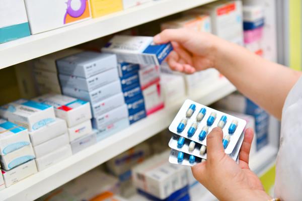 Pharmacist taking antibiotics off the shelf