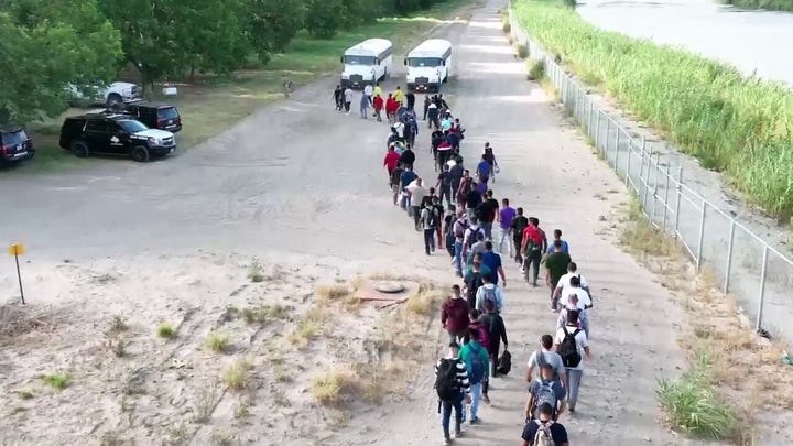 Drone footage shows migrants walking across the US-Mexico border